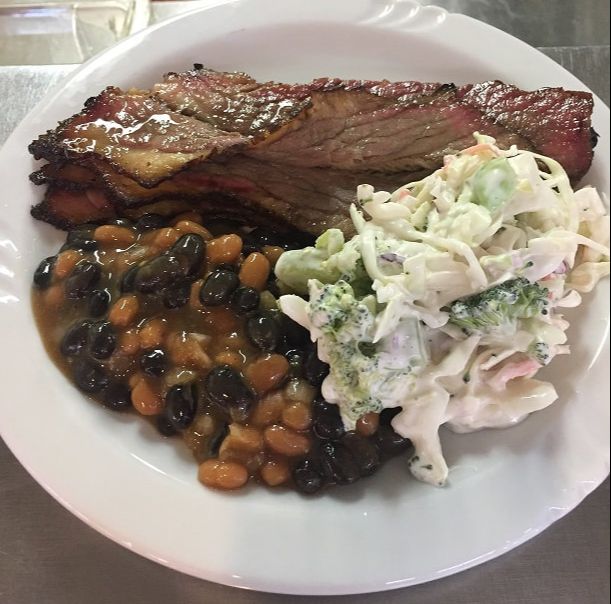 plate of food with meat, baked beans and cole slaw