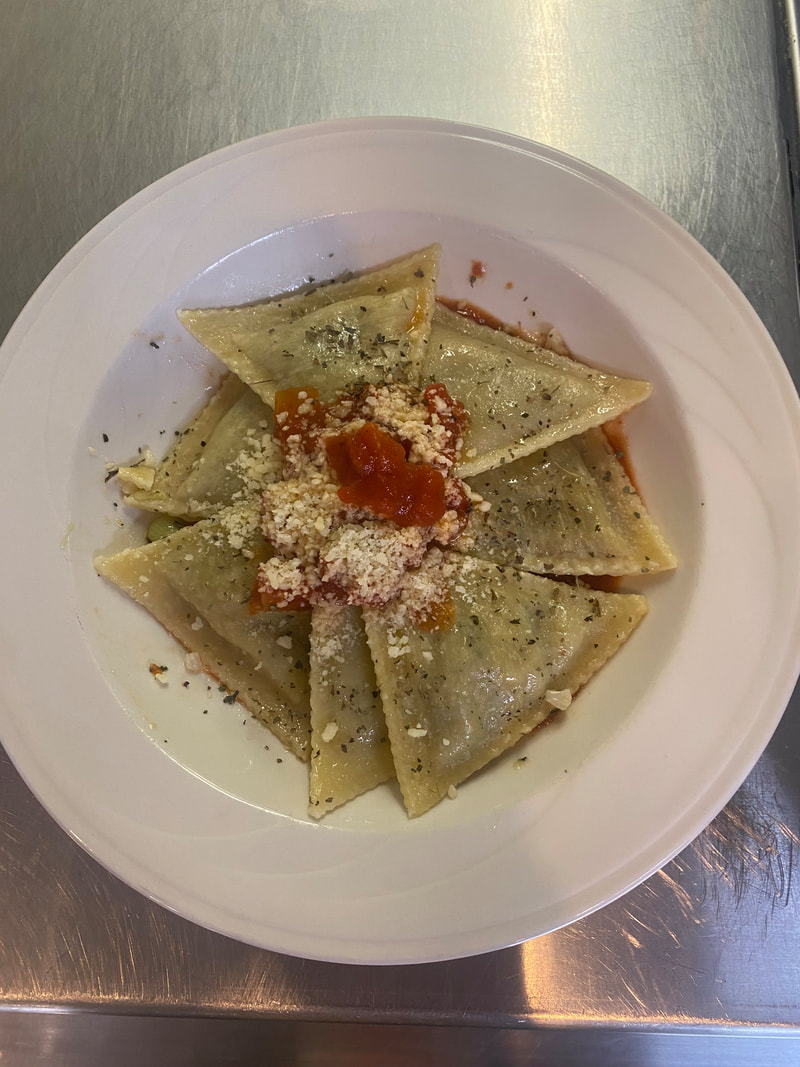 dish of ravioli with tomato sauce and grated parmesan